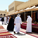 **

"A bustling marketplace in Doha, Qatar, filled with vibrant textiles and handcrafted goods. Fully clothed vendors in traditional Qatari dress are displaying their wares. Customers, also in modest attire, are examining carpets, jewelry, and wooden crafts. In the background, traditional Qatari architecture can be seen. The scene is filled with natural light, creating a warm and inviting atmosphere. safe for work, appropriate content, fully clothed, professional photography, perfect anatomy, natural proportions, family-friendly."

**